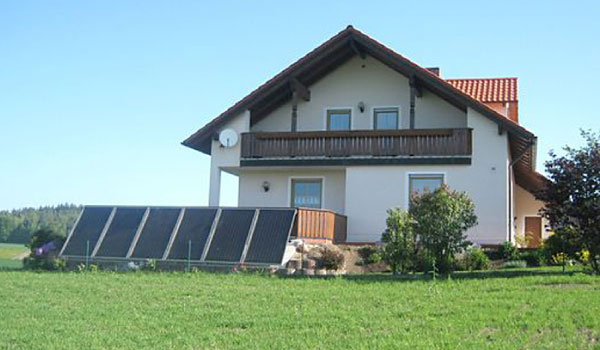 Solaranlage am Boden vor einem Wohnhaus